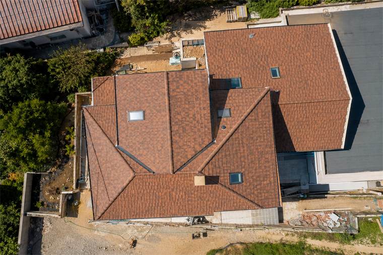 Vista dall'alto di un tetto a falde in tegole di cotto con lucernari, ripreso da drone